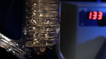 Kristall Spiral. Spiral- Glas Tube mit Wasser schließen hoch. Glas Spiral- Rohr von das Rückfluss Kondensator mit Laufen Wasser. Flüssigkeit Filtration im das Labor Experiment video