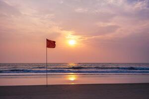 rojo bandera en playa en mar o Oceano como un símbolo de peligro. el mar estado es considerado peligroso y nadando es prohibido. foto