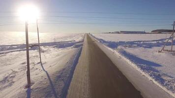 aéreo estradas. suv dirigindo dentro branco Nevado sempre-verde floresta em escorregadio asfalto estrada. aéreo Visão do a estrada e a Campos dentro a inverno video