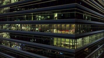 Singapur - 25 septiembre 2018. cerca arriba para exterior de moderno oficina edificio esquina con iluminado ventanas y personas adentro. disparo. aéreo de el céntrico oficina edificio esquina a noche, iluminado video