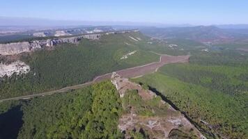 altai bergen verwijderd van de drone. schot. antenne visie naar landschap van groen vallei overstroomd met licht met weelderig groen gras, gedekt met steen, zomer dag onder een blauw lucht met altai bergen video