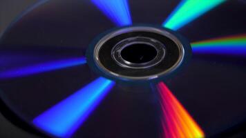 Compact disk isolated on black background. Abstract macro close up of colorful rainbow reflection from compact disc. Colorful abstract background. Rainbow on CD video