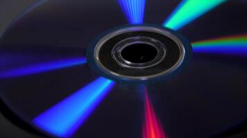 Compact disk isolated on black background. Abstract macro close up of colorful rainbow reflection from compact disc. Colorful abstract background. Rainbow on CD video