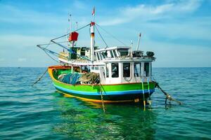 A fishing boat is pulling up on the beach photo