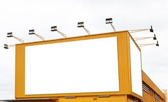 Mock up white background billboard on yellow building with spotlight. Clipping path for mockup photo