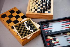 Board games on the table. Chess, backgammon, checkers. Boards are laid out for the game. Play, have fun at home. Leisure, hobbies. photo