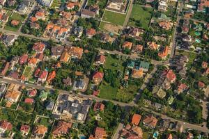 Residential area, rooftops, view from a drone. Cottages in the village. Land view through the airplane window. . Look out the window of a flying plane. Top view of the ground photo