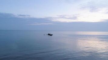 paesaggio marino con piccolo rocce In arrivo su di acqua e bellissimo blu nuvoloso cielo. sparo. romantico atmosfera nel tranquillo, calmo tramonto a mare. video