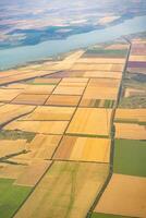 Land view through the airplane window. Fields, roads, rivers from a bird's eye view. Porthole. Look out the window of a flying plane. Top view of the ground photo