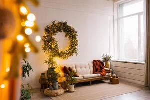 Fabulous Christmas interior of the Scandinavian-style living room with a sofa, pillows and Christmas trees with a wreath on the wall photo