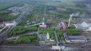 industrial fábrica e edifícios perto a estrada e estrada de ferro. aéreo visualizar. video