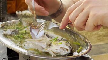 à la vapeur poisson avec citron vert poivre et divers nourriture Ingrédients sur table avec thaïlandais nourriture plats. en mangeant processus. haute qualité 4k métrage video