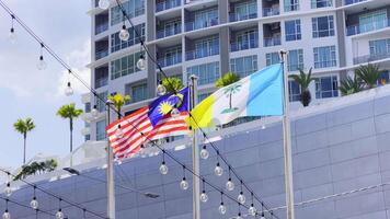 lento movimiento Malasia y Penang banderas ondulación juntos en ciudad arquitectura antecedentes. alto calidad 4k imágenes video