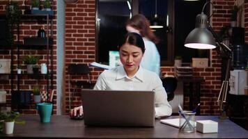 Zoom in on smiling businesswoman inputting financial data on laptop and analyzing sales report to plan business development. Close up of worker in office using device to do project research, camera A video