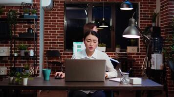 Employee tired while writing emails at computer desk, trying to freshen up by drinking coffee. Exhausted worker working overnight, typing on laptop, trying to get energy from caffeine, camera A video