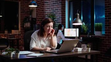 Employee calls manager remotely using internet videocall to ask for feedback on project progress. Worker in brick wall office requesting assistance from team leader in teleconference meeting, camera A video