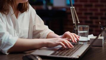 Close up shot of staff member in office late at night typing on laptop keyboard, doing tasks in office overnight. Employee inputting data for company project at computer desk video