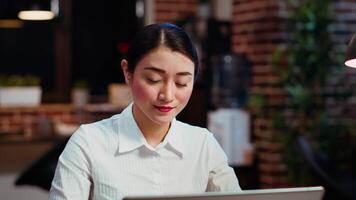 Zoom in on smiling businesswoman inputting financial data on laptop and analyzing sales report to plan business development. Close up of worker in office using device to do project research, camera B video