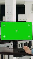 vertikal video operatör av företag förlita sig på Chromakey isolerat grönskärm visa. företag verkställande använder sig av dator på börja arbetsplats medan granskning attrapp mall, arbetssätt i byrå kontor. stativ skott.