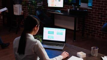 Worker looks over statistical data financial graphs on laptop screen, researching key data for company project. Businesswoman analyzing stock market figures and charts on electronic device, camera A video