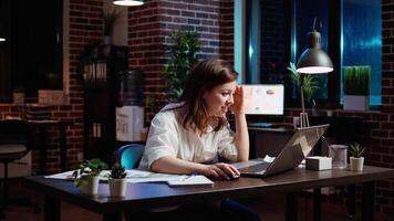 Happy employee reading email on laptop received from customer, excited after managing to secure lucrative deal for company. Businesswoman celebrating finalizing agreement with client, camera A video