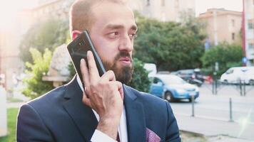 retrato do jovem homem de negocios falando em a telefone dentro lente chamas, seletivo suave foco tomada. lento movimento cenas video