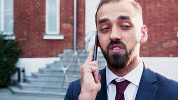 Spinning slow motion of businessman talking on the phone outdoor in the city. Beautiful lens flares from behind video