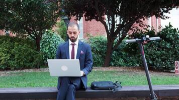 manager Lavorando su il partire su il il computer portatile. lui sitts all'aperto e tipi su il computer. lento movimento tiro video