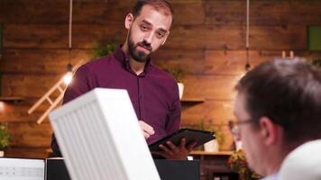 Jeune architecte ayant une conversation avec le sien collègue dans le Bureau à propos Nouveau grattes ciels video