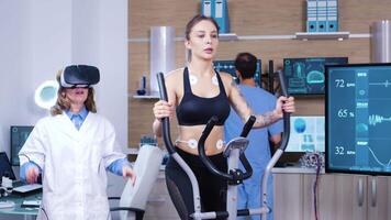 femmina medico nel sport scienese indossare virtuale la realtà occhiali mentre femmina atleta in esecuzione con elettrodi allegato per sua corpo. video