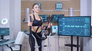 Beautiful young athletic women in sportswear runs on treadmill in scientific sport laboratory video