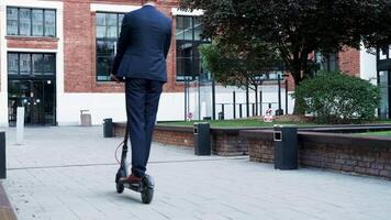 manager in bedrijf wijk rijden zijn elektrisch scooter naar of van de werk, langzaam beweging beeldmateriaal video