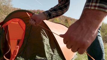 Close up view of man checking the camping tent after setting it up. Tourist in the campsite. video