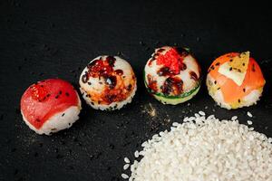 Sushi marco panorama, gastos generales plano laico disparo. rollos, maqui, nigiri en un negro pizarra fondo, japonés comida panorámico bandera. salmón, Anguila, camarón, atún con arroz, con Copiar espacio. alto calidad foto