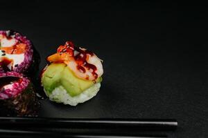Sushi frame panorama, overhead flat lay shot. Rolls, maki, nigiri on a black slate background, Japanese food panoramic banner. Salmon, eel, shrimp, tuna with rice, with copy space. High quality photo