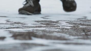 Close-up of male legs in winter shoes walking on snow. Footage, View of walking on snow with Snow shoes and Shoe spikes in winter. Men's legs in boots close up the snow-covered path video