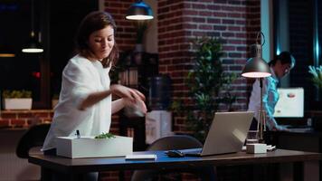 Woman packing desk belongings, excited to change offices after finally being promoted, hugging asian coworker. Joyful employee being advanced in company hierarchy rank, celebrating, camera B video