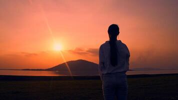 Woman standing watching the sunset. photo