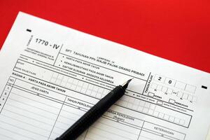 Indonesian tax form 1770-4 Individual Income Tax Return and pen on table photo