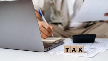 Man is calculating annual tax, monthly expenses with calculator and filling form of Individual Income Tax Return. Season to pay Tax and Budget planning concept. photo