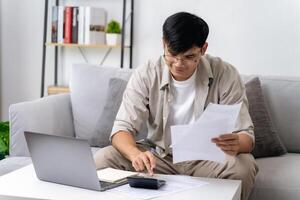 Man is calculating annual tax with calculator and filling form of Individual Income Tax Return. Season to pay Tax and Budget planning concept. photo