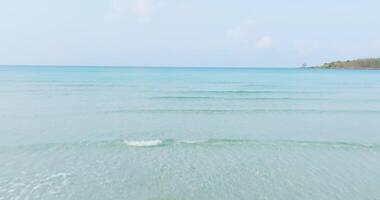 Aerial drone view of clear turquoise sea and waves over the beach video