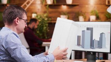 Architect in the office holding a model for a new building offices. Architecture development. video