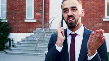 Man in business suit talking on the phone, outdoor in the city. Slow motion footage video