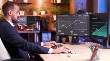 Investment manager in suit working on computer during night time with moon light coming from the window. video