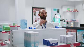 farmacista fare inventario utilizzando ologramma proiezione, conteggio scatole di medicamenti e supplementi. farmacia dipendente Lavorando su procurare medico forniture, artificiale intelligenza. telecamera 1. video