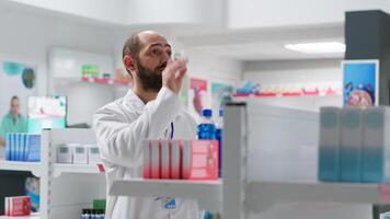 farmacéutico haciendo inventario utilizando holograma proyección, contando cajas de medicamentos y suplementos farmacia empleado trabajando en proxenetismo médico suministros, artificial inteligencia. cámara 2. video