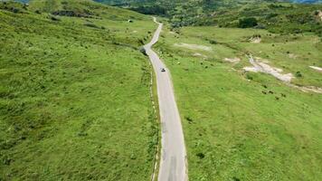 Drone following a car in a beautiful rural landscape. Aerial view video