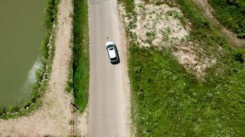 Top down aerial view of an SUV on a rural road. Drone footage video