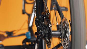 Close up shot of bicycle wheel mechanism being examined by woman during performance assessment. Focus on bike components tested by professional in blurry background ensuring proper function video